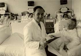 Dr. Günter-Otto Maus neben einem Patienten am Krankenbett